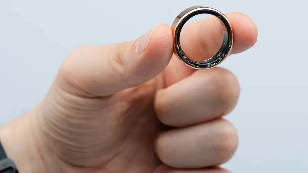 Ręka trzymająca smart ring w kolorze